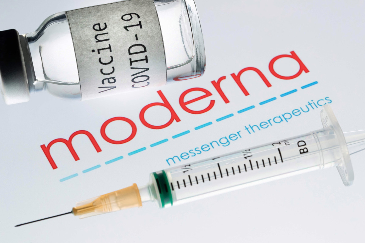 a syringe and a bottle reading Vaccine Covid-19 next to the Moderna biotech company logo.
