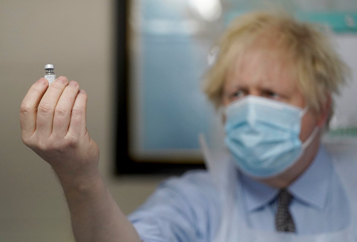 Prime Minister Boris Johnson holds a bottle of the Pfizer BioNTech vaccine during a visit to a coronavirus vaccination centre in Batley, West Yorkshire