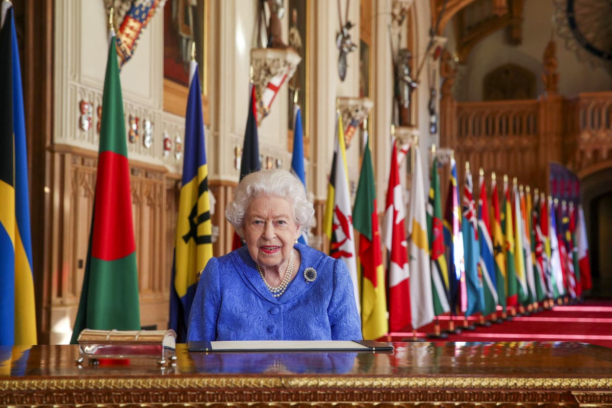 Smiling Queen pictured against backdrop of flags for Commonwealth Day