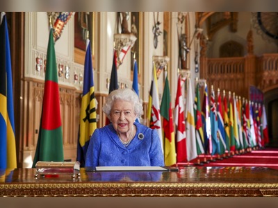 Smiling Queen pictured against backdrop of flags for Commonwealth Day