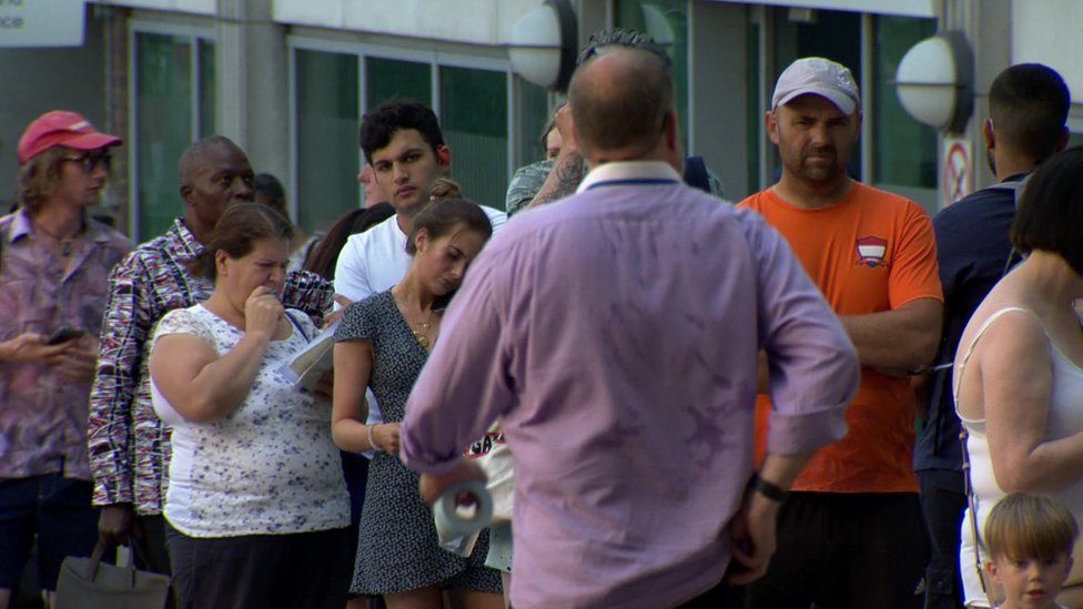 Passport delays force long queues in heatwave