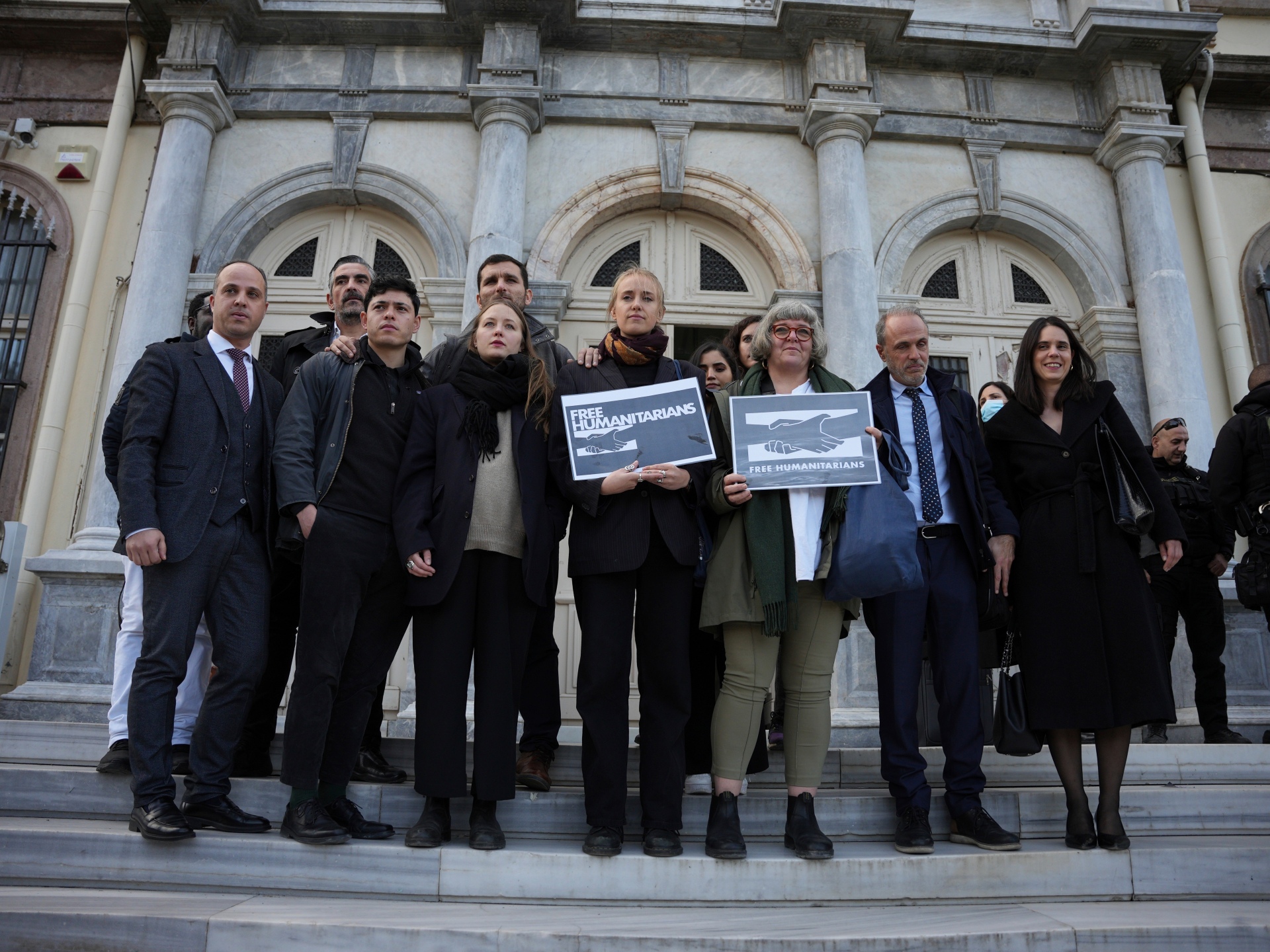 Protesters, laywyers and aid workers pose for the media outside a court in Mytilene, on the northeastern Aegean island of Lesbos, Greece